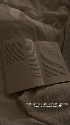 an open book sitting on top of a bed