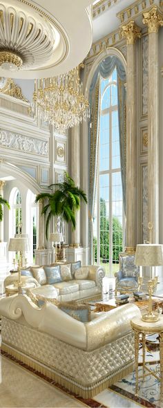 an elegant living room with chandelier, couches and two large potted plants