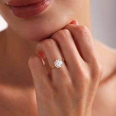 a close up of a person wearing a ring with a diamond on the middle finger