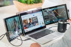 a man sitting at a desk with three laptops