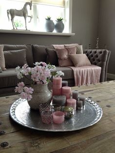 a living room filled with lots of furniture and flowers on top of a wooden table