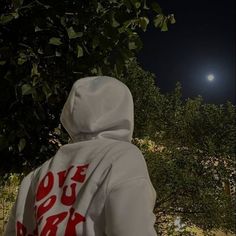 a person wearing a hoodie with the moon in the background