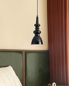 a lamp hanging over a bed next to a window