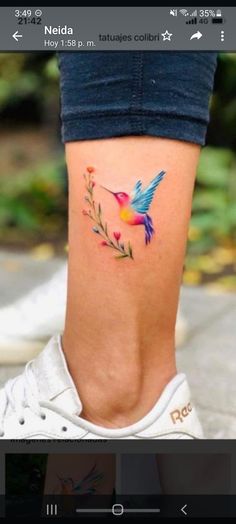 a small tattoo on the leg of a woman's lower body, with colorful birds and flowers