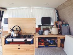 the inside of a camper with an oven, stove and coffee pot on it