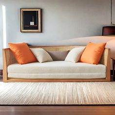 a white couch with orange pillows in a living room