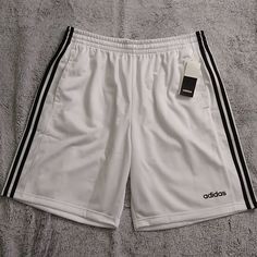 Men's Adidas Athletic Shorts. Classic Three Stripes Down Each Leg. Small Logo On Left Thigh. Elastic Waistband With Drawstring. New With Tags White Three Stripes Athletic Shorts For Sports, White Three Stripes Athletic Shorts, Adidas Sporty White Athletic Shorts, White Three-stripe Sports Shorts, White Adidas Sports Shorts, White Shorts With Three Stripes, White Cotton Shorts With Three Stripes, White Three Stripes Shorts, Adidas White Athletic Shorts With Moisture-wicking