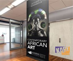 an empty room with wooden floors and a large sign on the wall that says contemporary african art