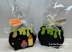 two black bags with green and orange designs on them, one is filled with candy