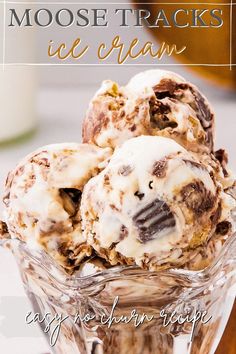 three scoops of ice cream sitting in a glass bowl on top of a table