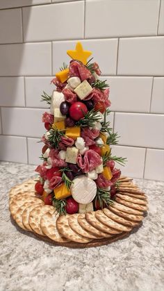 a christmas tree made out of crackers and meats on a counter top with white tiles