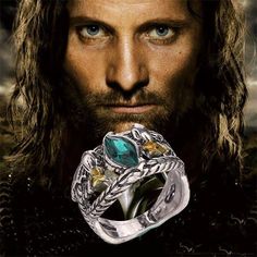 a man with long hair and blue eyes wearing a ring in front of his face