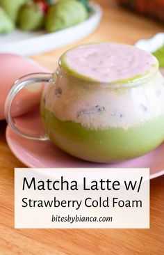 matcha latte w / strawberry cold foam in a teapot on a pink plate