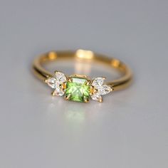 *Condition: Brand new *Center Stone: Natura Olivine from Brazil, Asscher Cut, 5mm, Approx 0.75ct *Side Stone: Natural white diamond, marquise cut (VS1 clarity and F color) *Ring Weight: 2.65g (depend on the ring size) *Metal Purity: Optional *Each piece is made-to-order with care and special attention to detail. all items are made with conflict-free diamonds and gems. *The item will be gift wrapped and shipped. --------------------------------------------------------- Available in : 14k Rose or Diamond Asscher Cut Rings For May Birthstone, Asscher Cut Diamond Ring For May Birthstone, Dainty Green Diamond Ring For Formal Events, Dainty Green Diamond Ring For Formal Occasions, May Birthstone Asscher Cut Diamond Ring, May Birthstone Asscher-cut Diamond Ring, Elegant Tsavorite Birthstone Ring, Fine Jewelry Asscher Cut Cubic Zirconia Emerald Ring, Fine Jewelry Cubic Zirconia Emerald Ring Asscher Cut