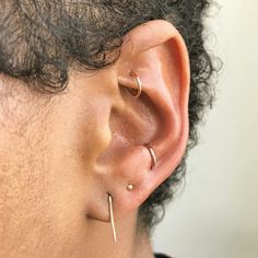 a close up of a person with ear piercings on their ears and behind the ear