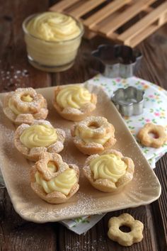 small pastries are on a plate with powdered sugar and butter in the background