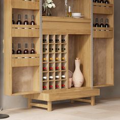 a wooden cabinet filled with lots of bottles next to a vase and other items on top of it