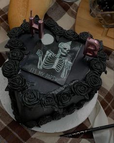 there is a cake with a skeleton on it and candles in the shape of a heart