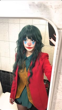 a woman with green hair and makeup is standing in front of a mirror