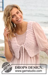 a woman standing on the beach talking on her cell phone and smiling at the camera