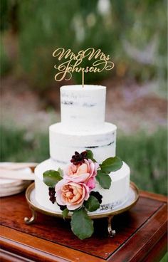 a white wedding cake with pink flowers on top