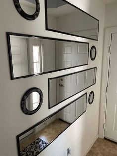 three mirrors are hanging on the wall in front of a door and another mirror has been placed above it