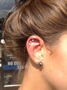 a woman's ear with two piercings on it