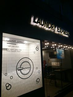 a laundry express store front at night with its lights on and the sign lit up