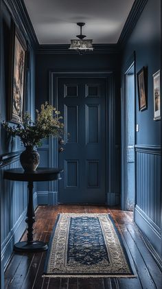 a hallway with blue walls and wooden flooring is lit by a chandelier