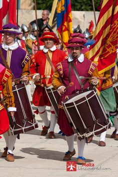 a group of men in red and yellow uniforms playing drums