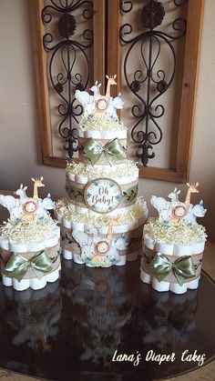 a three tiered cake sitting on top of a table next to two smaller cakes