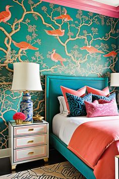 a bedroom decorated in teal, pink and orange with birds on the wall behind the bed