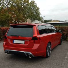 a red car is parked in the parking lot