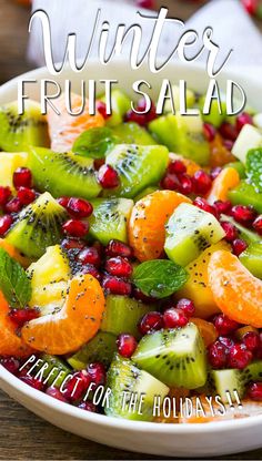 winter fruit salad with oranges, kiwi and pomegranate in a white bowl