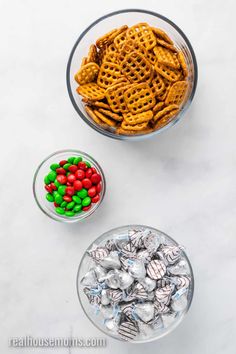 two bowls filled with candy and pretzels on top of a white countertop