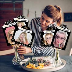 a woman sitting at a table with some flowers in front of her and photos on the plate