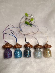 five small glass jars with glitter on them