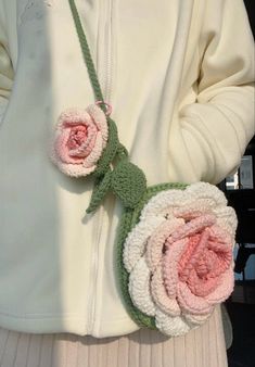 a close up of a person wearing a white jacket and pink flowers on their necklace