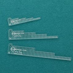 three clear plastic rulers on a green surface