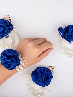 a woman's hand is shown with blue flowers and pearls on her bracelets