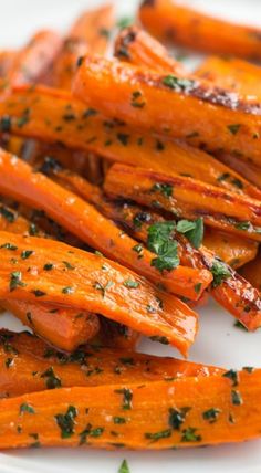 cooked carrots with herbs and seasoning on a white plate