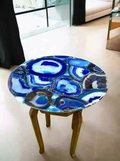 a blue and white table sitting on top of a hard wood floor next to a window