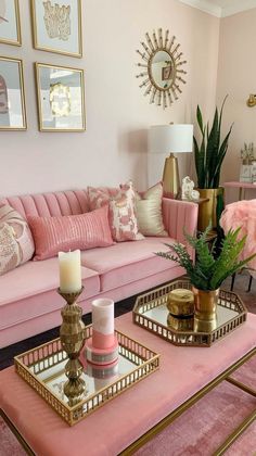 a living room with pink couches and gold trays