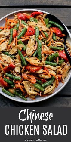 chinese chicken salad with carrots, green beans and red bell peppers on a white plate