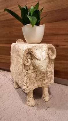 an elephant planter with a potted plant on top