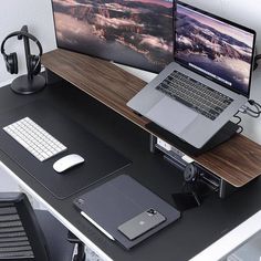 a laptop computer sitting on top of a wooden desk next to a monitor and keyboard