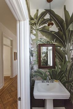 a bathroom sink sitting under a mirror next to a doorway