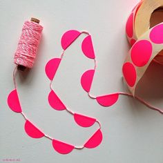 pink polka dot garland and spool of thread on white background with text overlay that says sticker dot garland diy kit