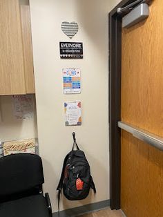 the door to an office with a backpack hanging on it