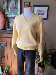 This knit pullover sweater is made from pure wool in a beautiful soft buttery yellow with a v-neckline and folded cuffs.  Label: Shelby Wool Paca Size: Medium Measurements (taken flat): Pit to pit - 19.5" Hem - 17" Shoulder to hem - 23.5" Pit to hem - 12.5" Great vintage condition - there is just one very small brown spot in the right sleeve as pictured Feel free to message me for more measurements, pictures, or to ask any other questions you might have! Please see my shop policies regarding shi Yellow V-neck Sweater Affordable, Vintage V-neck Knit Sweater, Spring Wool V-neck Sweater, Yellow Knit V-neck Sweater, Spring V-neck Wool Sweater, Vintage Knit V-neck Sweater, Vintage V-neck Knitted Tops, Vintage V-neck Sweater For Fall, Classic Yellow Sweater For Fall